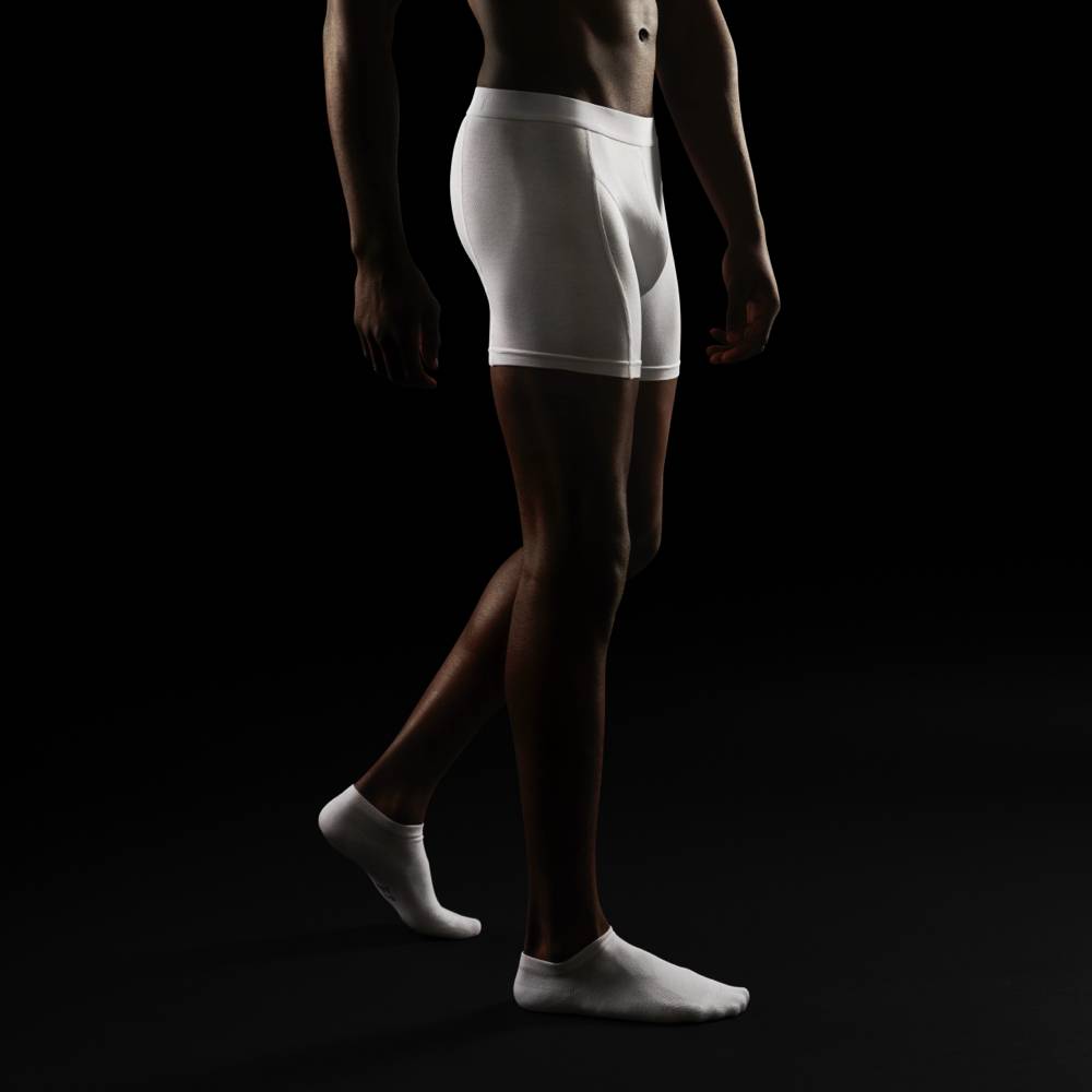 Man wearing white boxershort and opening KIIIT packaging